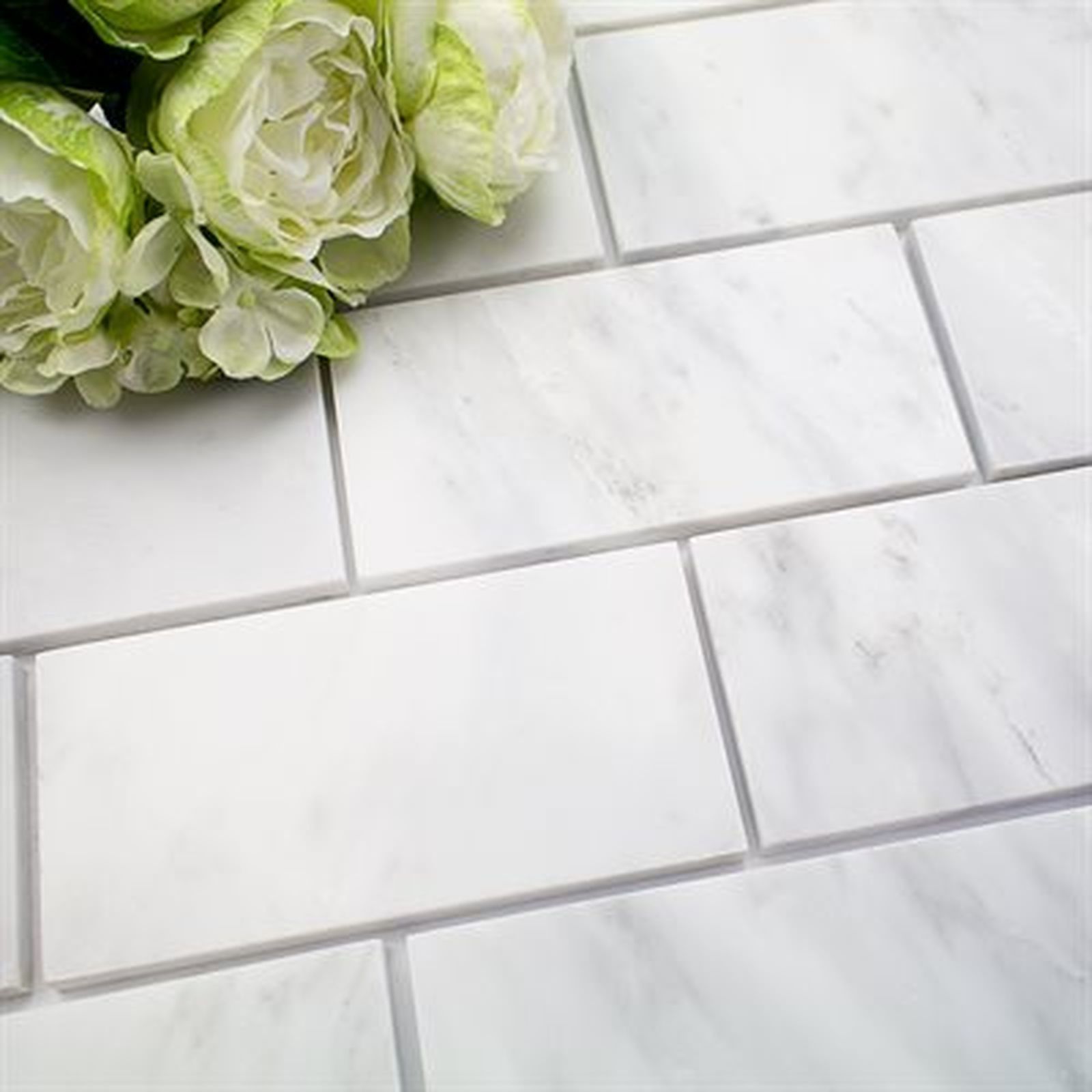 White marble subway tiles with white flowers.