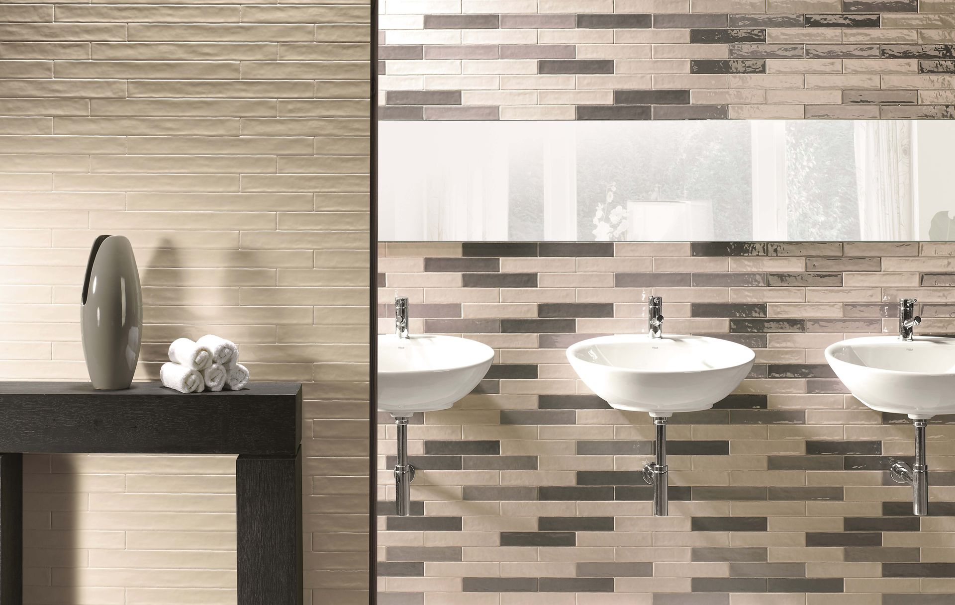 Bathroom with three sinks, mirror, and textured tile wall.  A vase and towels are on a dark counter.