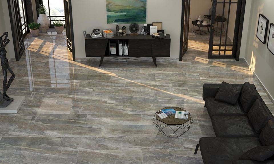 Modern living room with dark gray tile flooring, a leather sofa, and a black cabinet.