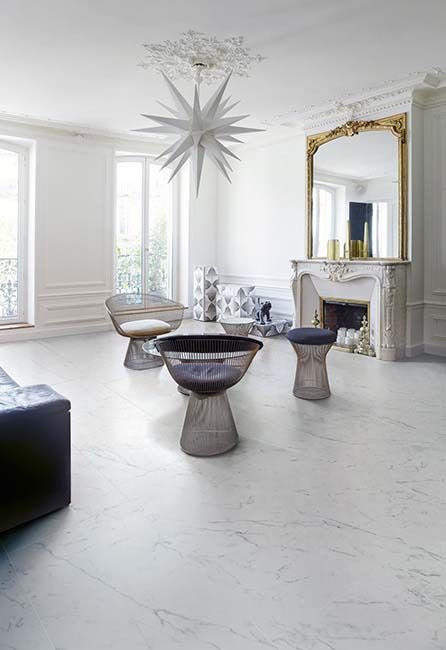 White living room with starburst light fixture, fireplace, mirror, and modern furniture.