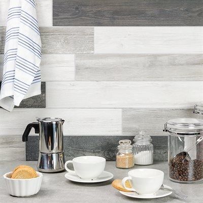 Coffee setup: Cups, bread, coffee maker, jars, and gray-wood backsplash.