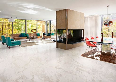 Spacious modern living room with large windows, fireplace, and marble floors. Furniture includes sofa and dining table.