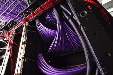 Un montón de cables morados salen de una caja negra.
