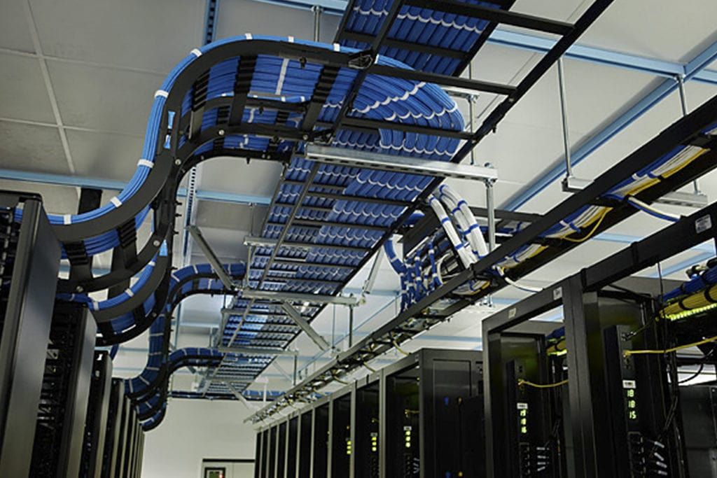 Una sala de servidores con muchos cables colgando del techo.