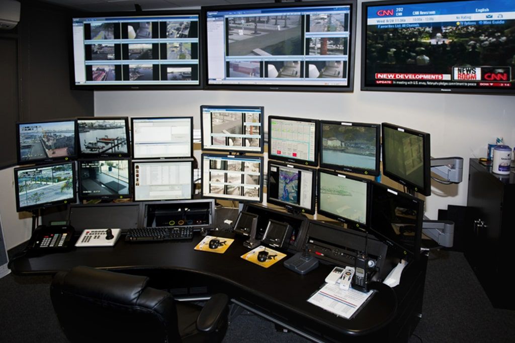 Una sala de control con muchos monitores en la pared.