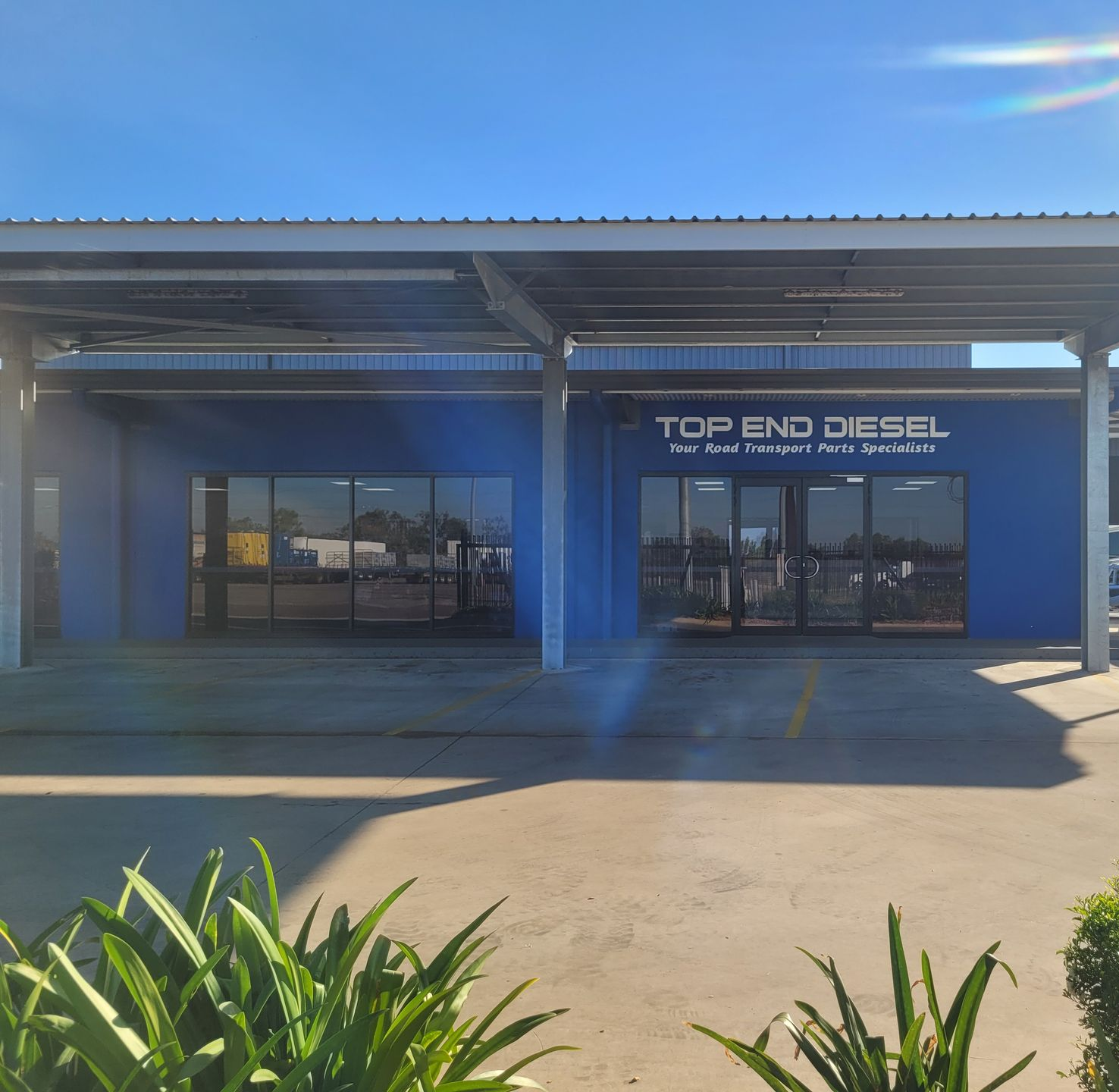 Top End Diesel business exterior with blue walls, a covered entrance, and a white vehicle parked nearby — Top End Diesel In Wishart, NT
