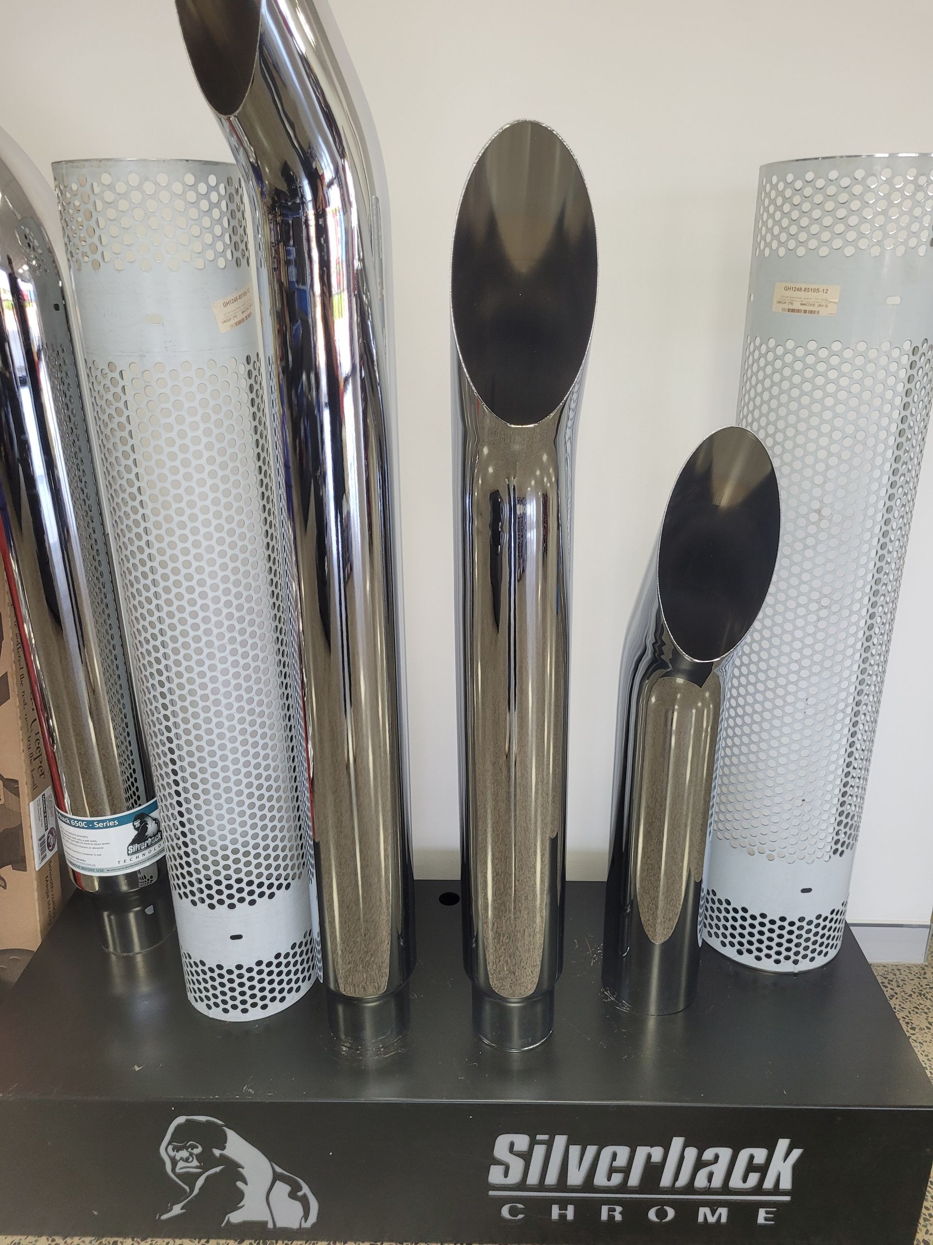 Chrome exhaust stacks and decorative screens on a display shelf, branded 
