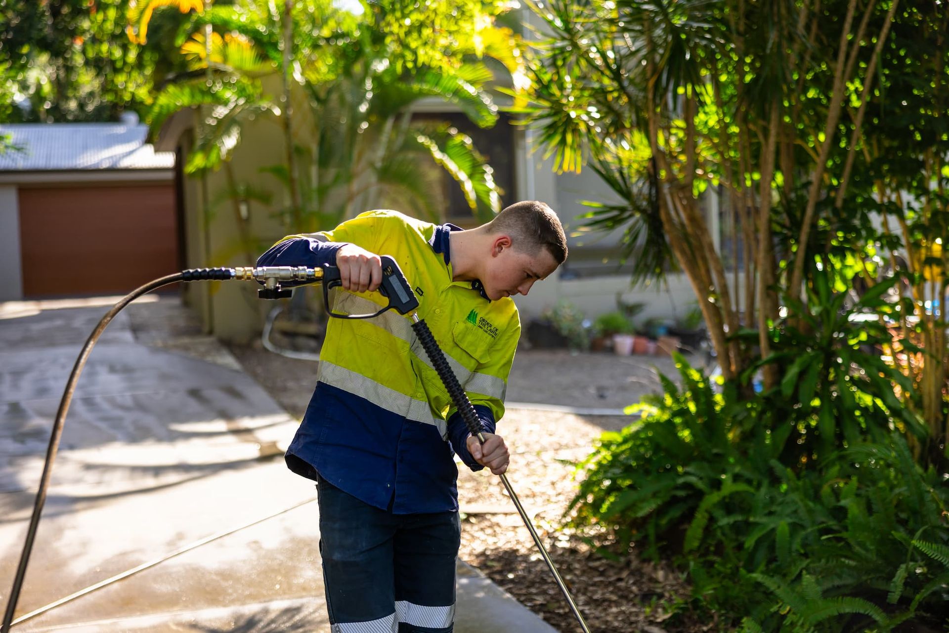A man is Brisbane pressure washing a surface