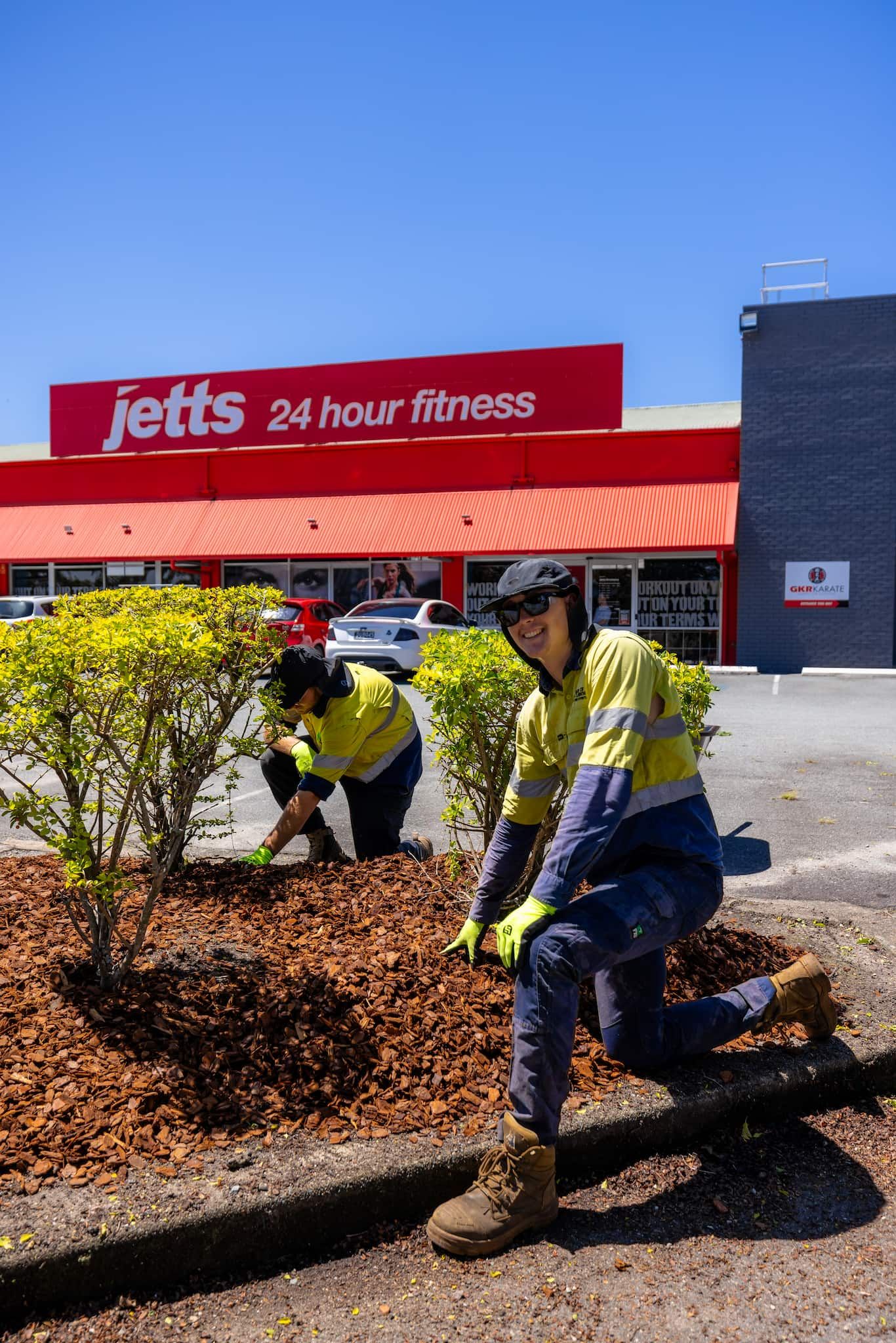 A man is using a lawn mower to cut the grass in a backyard.
