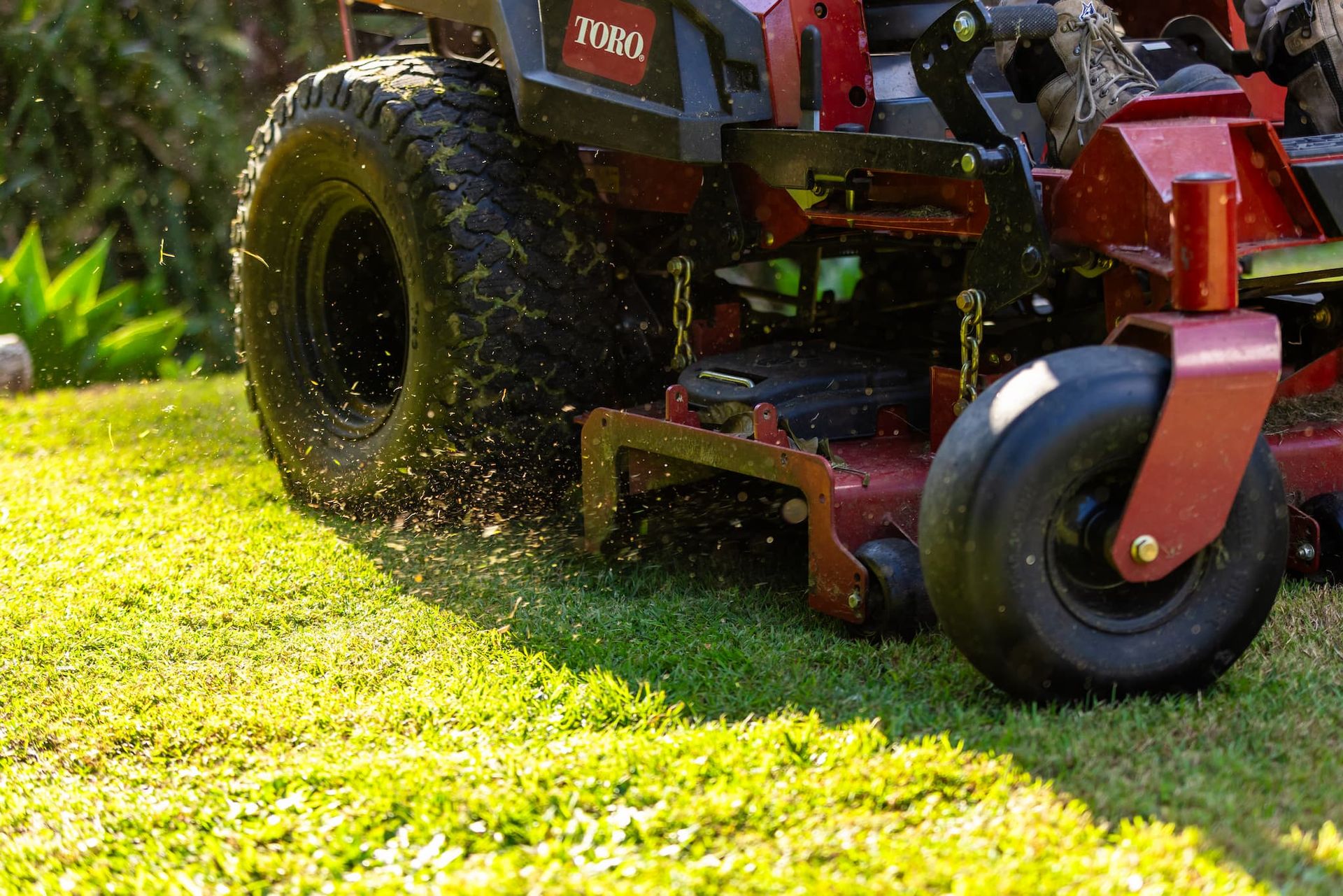 A lawn mower is cutting a lush green lawn.