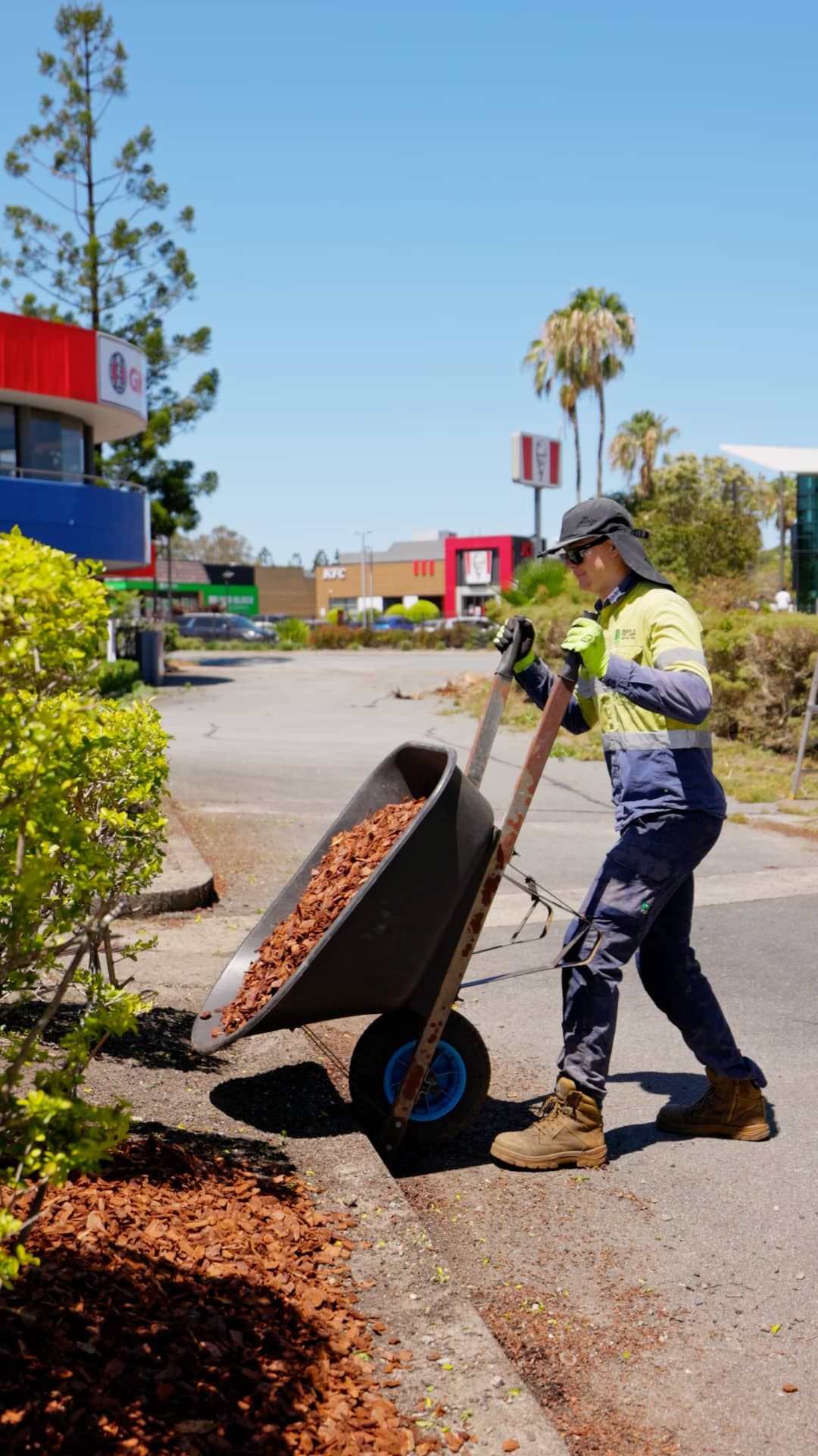 A person pouring mulch out of a wheelbarrow