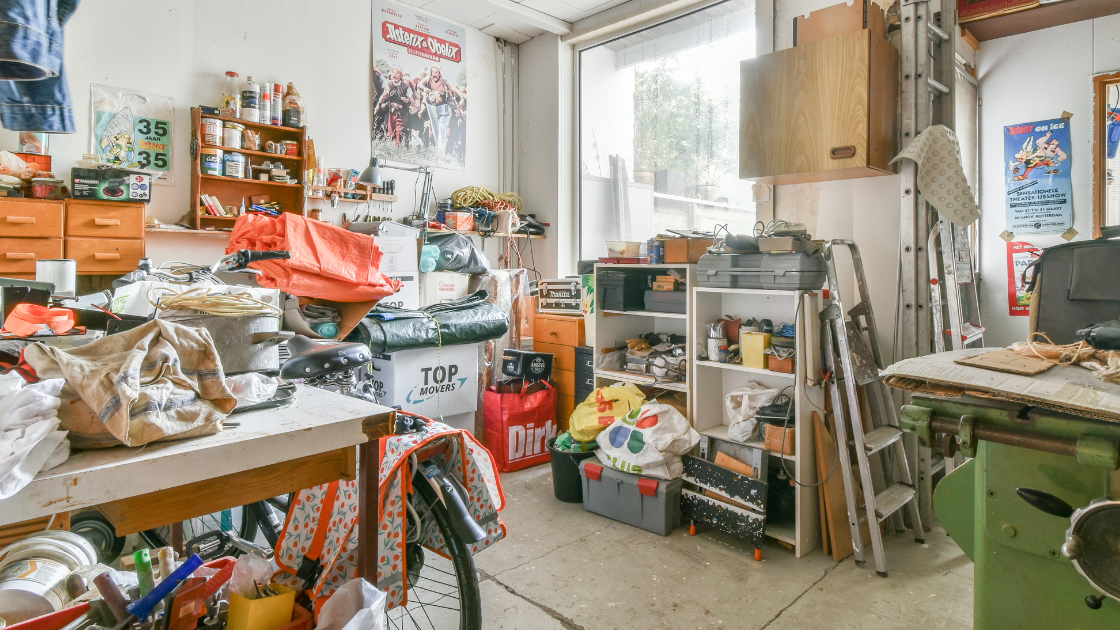 A messy room with a lot of tools and a table.