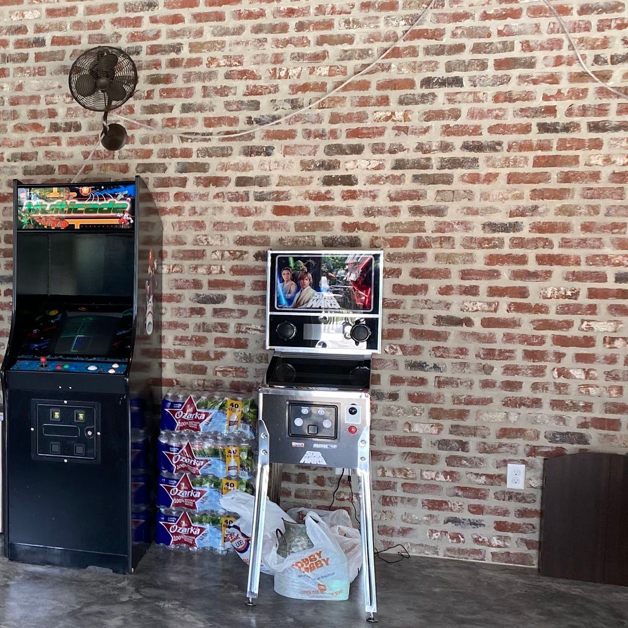 A room with a brick wall and a pinball machine