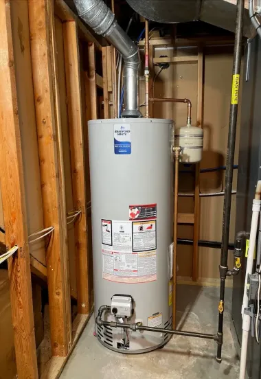 Basement utility room with a white water heater, exposed studs, and metal ductwork.