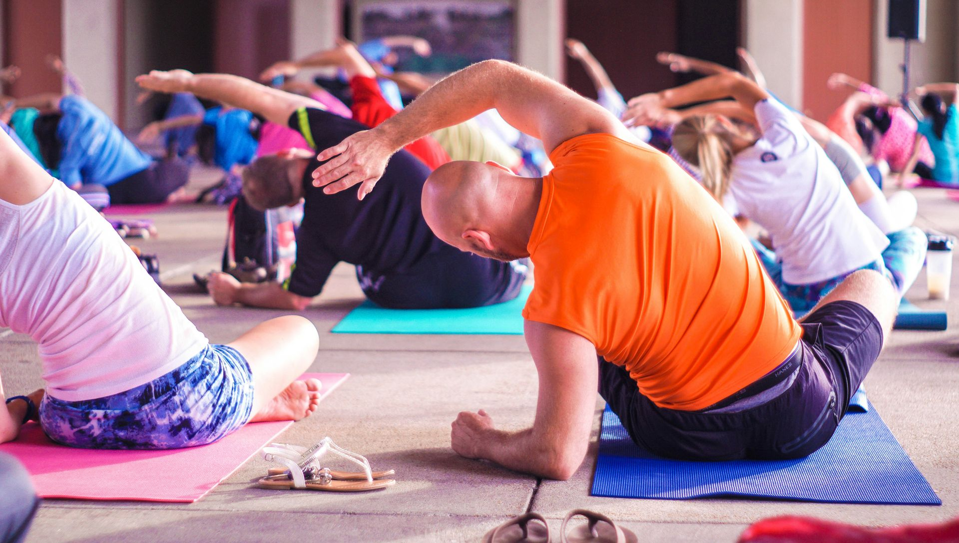 People doing yoga poses on mats outdoors.