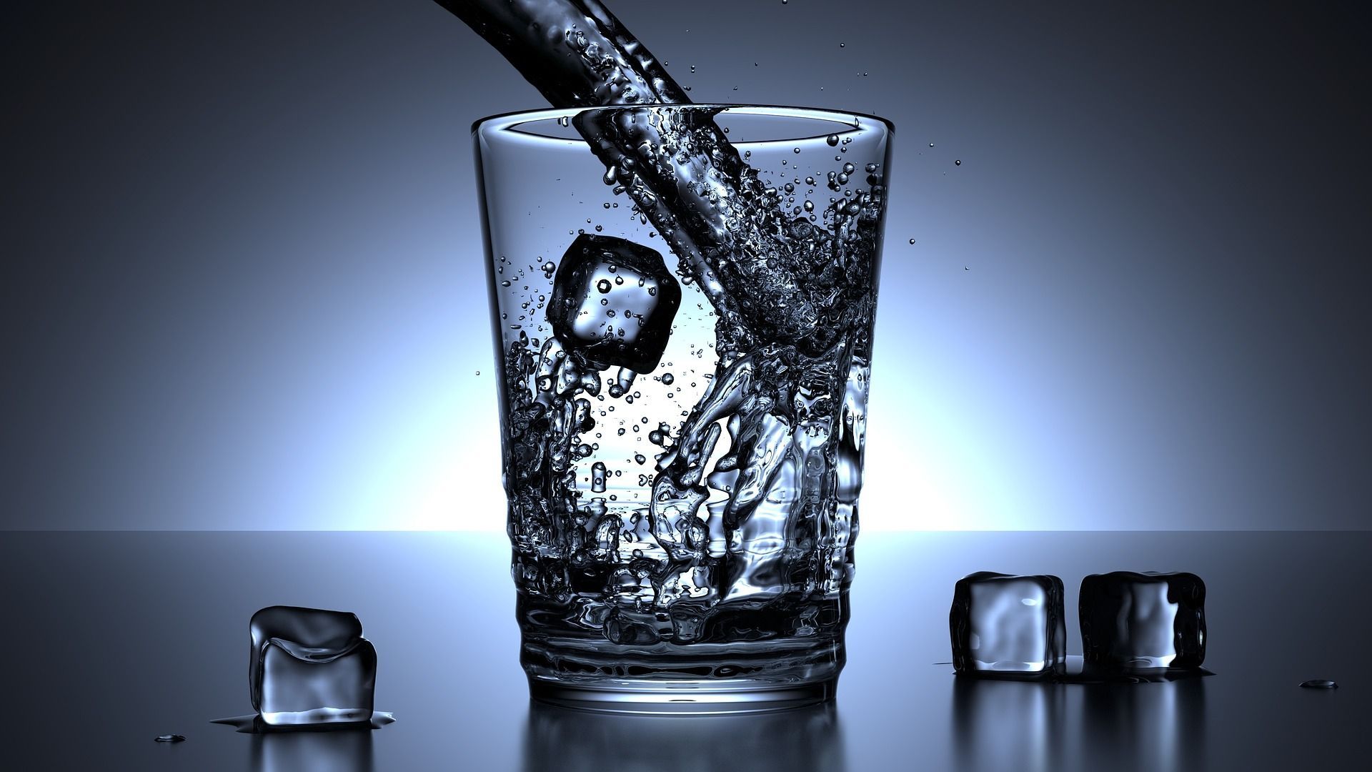 Water pouring into a glass with ice cubes on a reflective surface; blue tones.