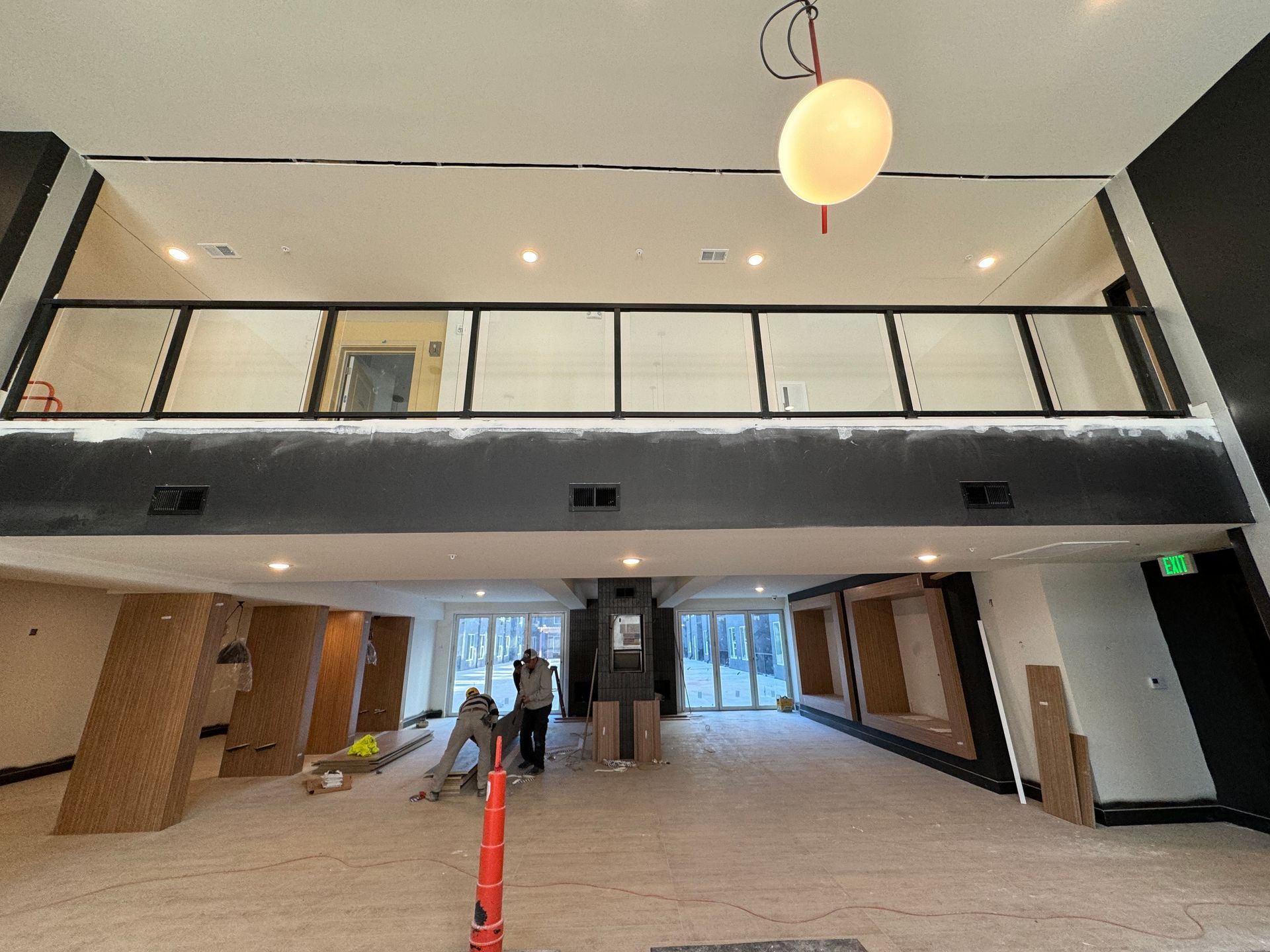 A large room with a balcony, a handrail and a lamp hanging from the ceiling.