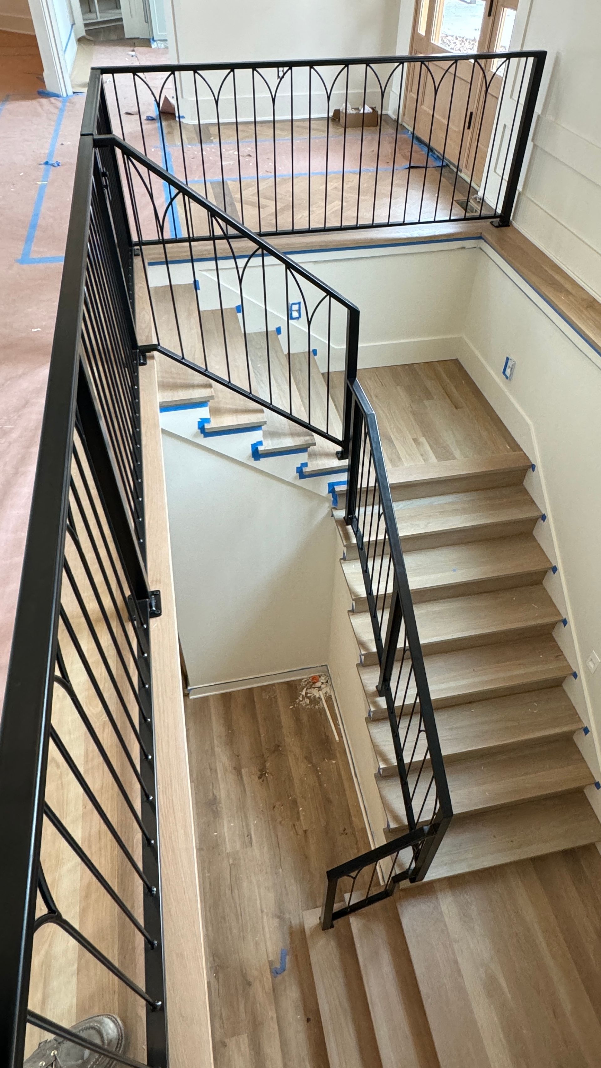An aerial view of a staircase with a wrought iron railing.