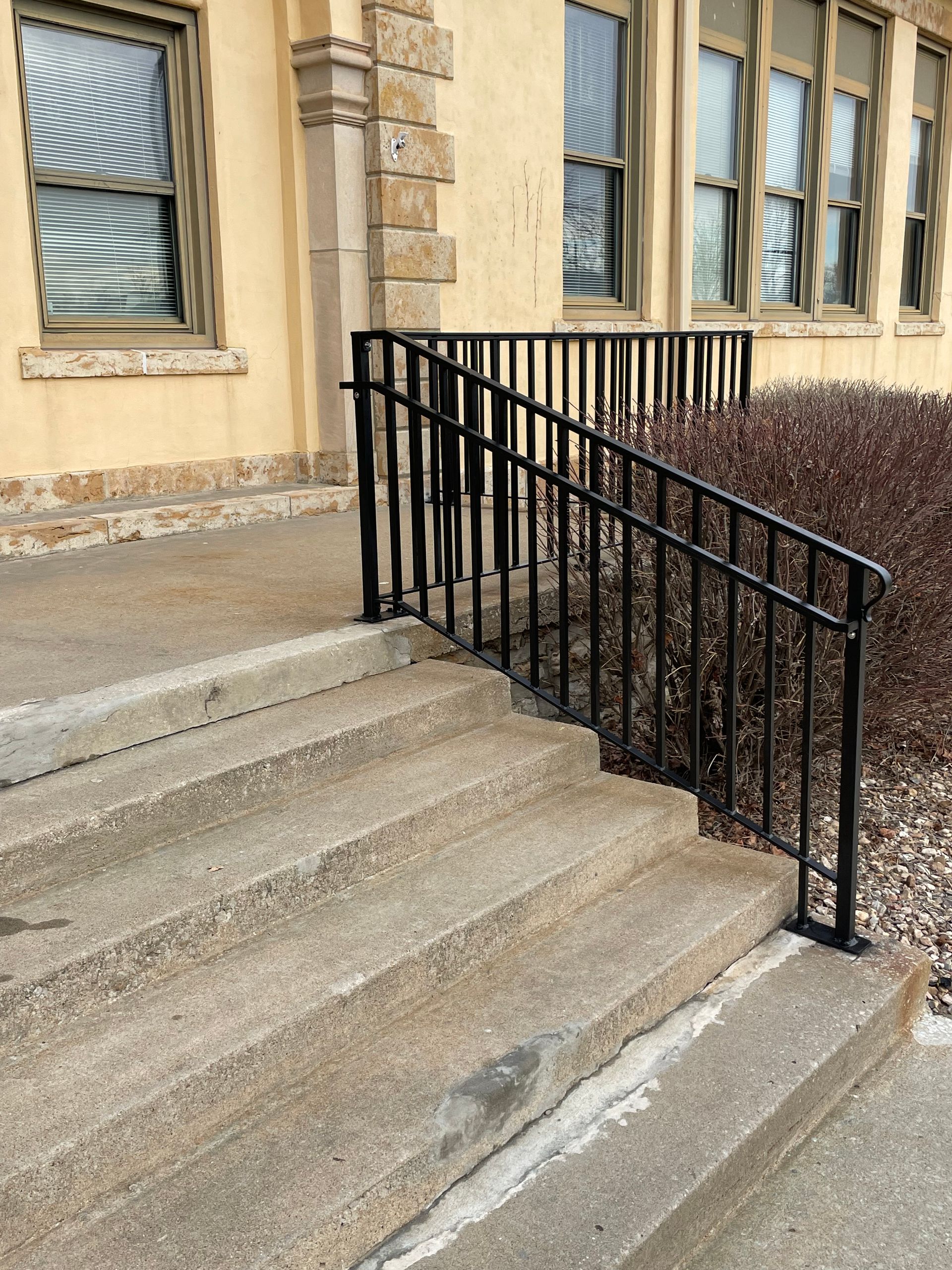 A set of stairs with a metal railing in front of a building