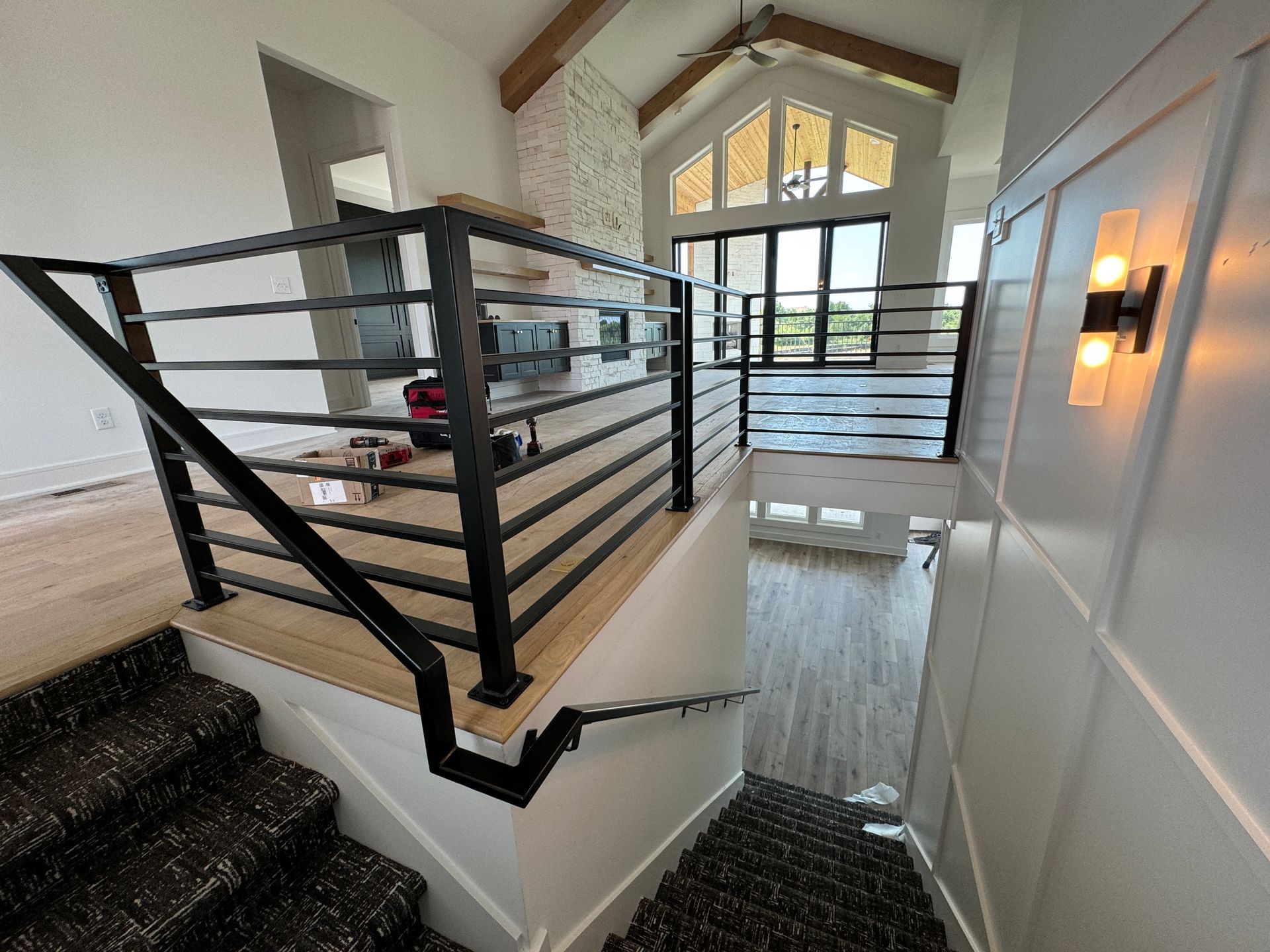 A staircase with a black railing leading up to the second floor of a house.