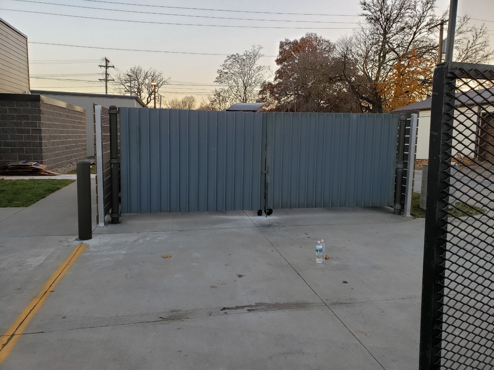 A trash gate with a bottle of water in front of it