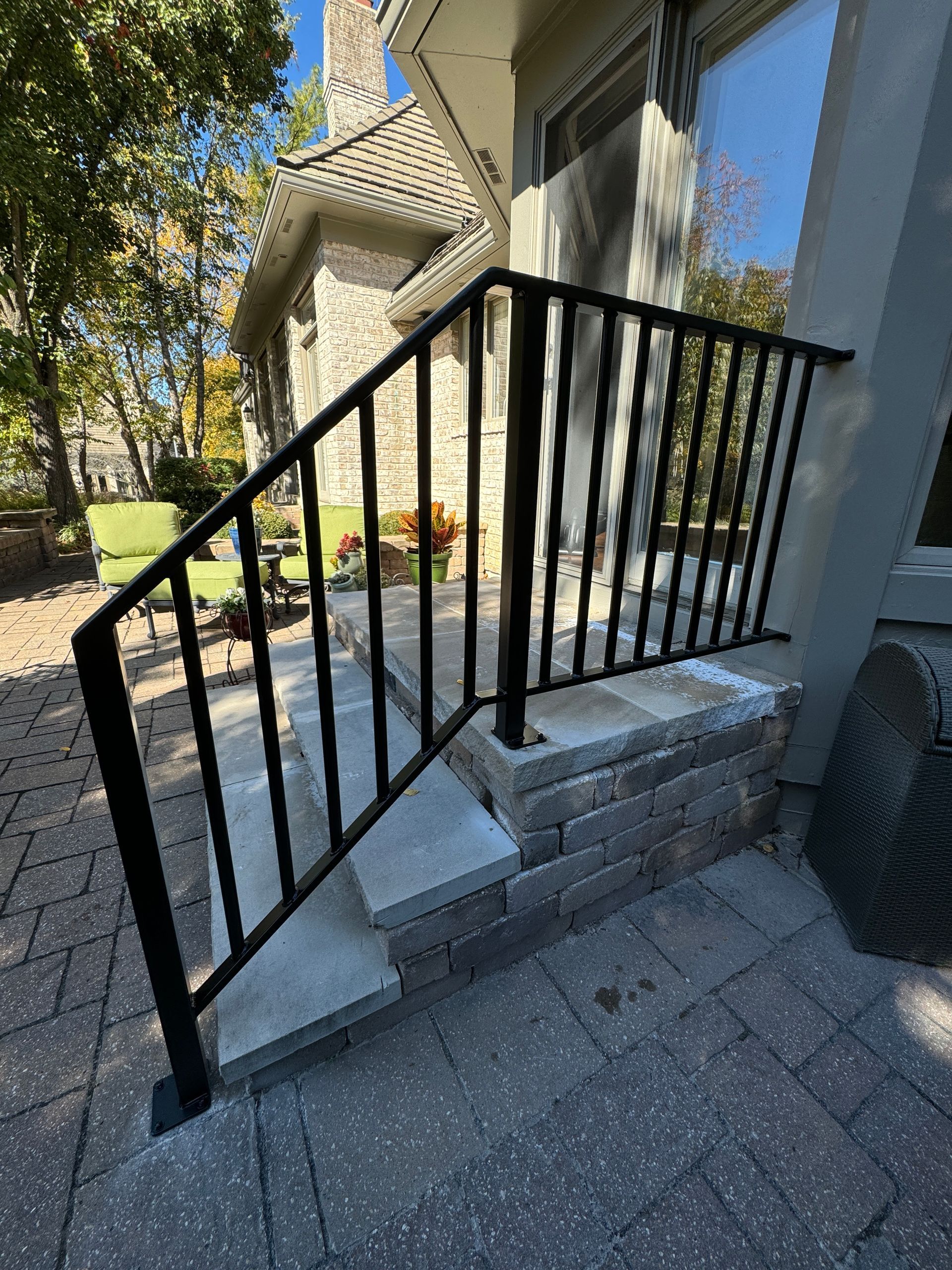 There is a black railing on the steps of a house.