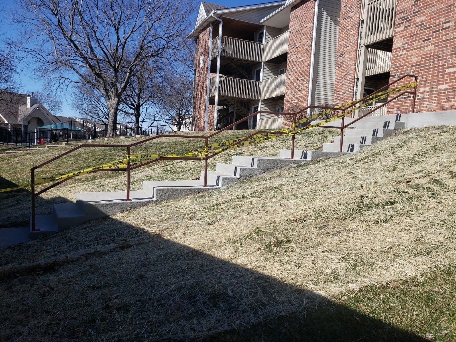 A set of stairs leading up to a brick building with railing