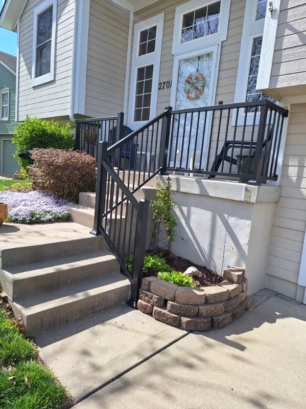 A house with a porch and stairs with a black railing