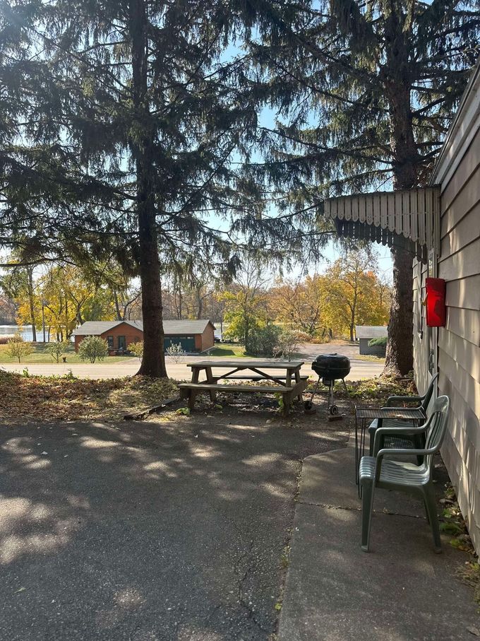 There is a picnic table and chairs in the backyard of a house.