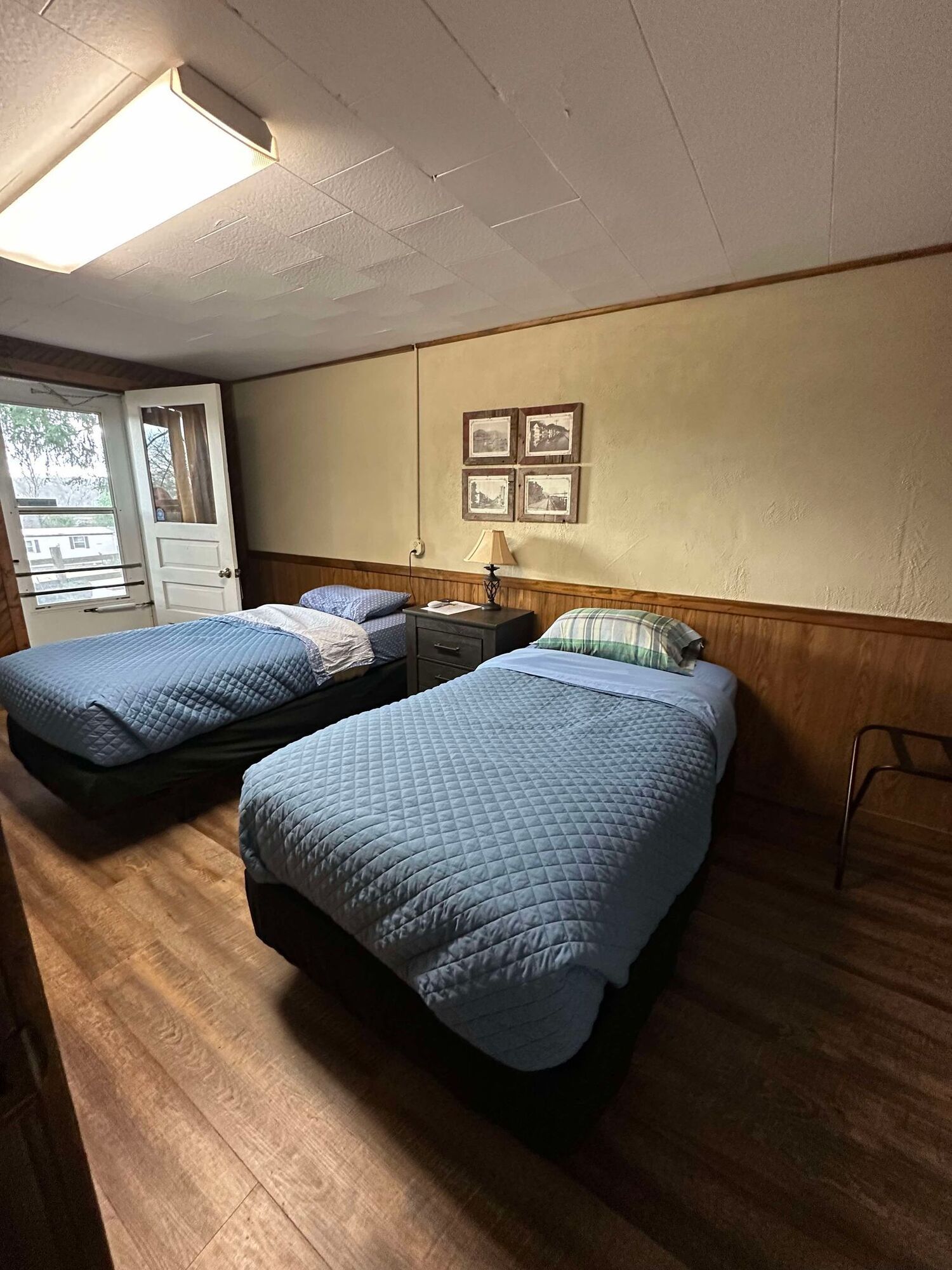 A bedroom with two twin beds , a nightstand , and a window.