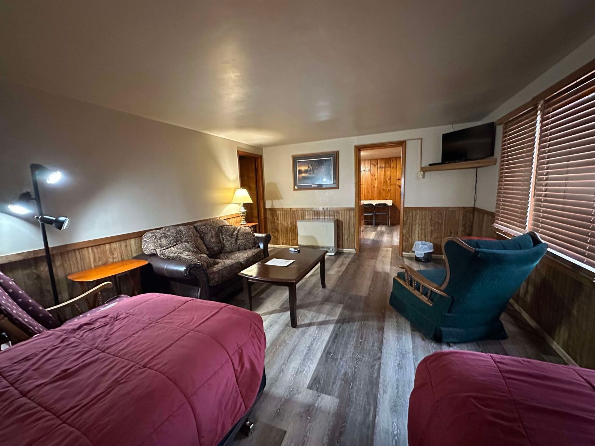 A living room with a couch , chair , table and two beds.