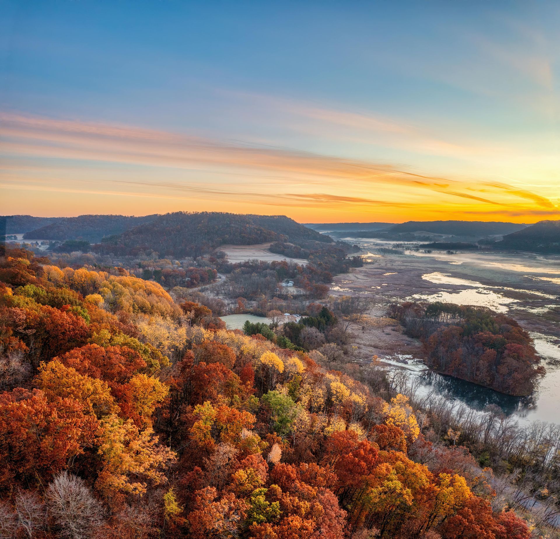 A sunset over a mountain range with a lot of fog