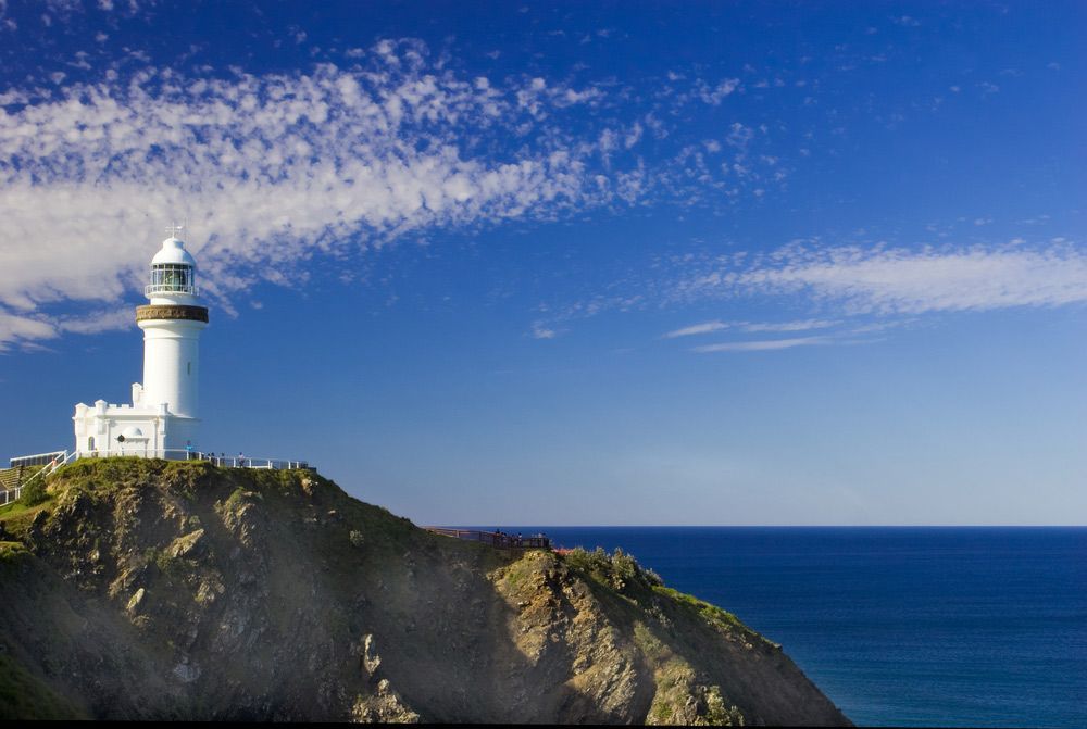 A Lighthouse On Top Of A Cliff Overlooking The Ocean — All Roof Restorations & Solar In Byron Bay, NSW
