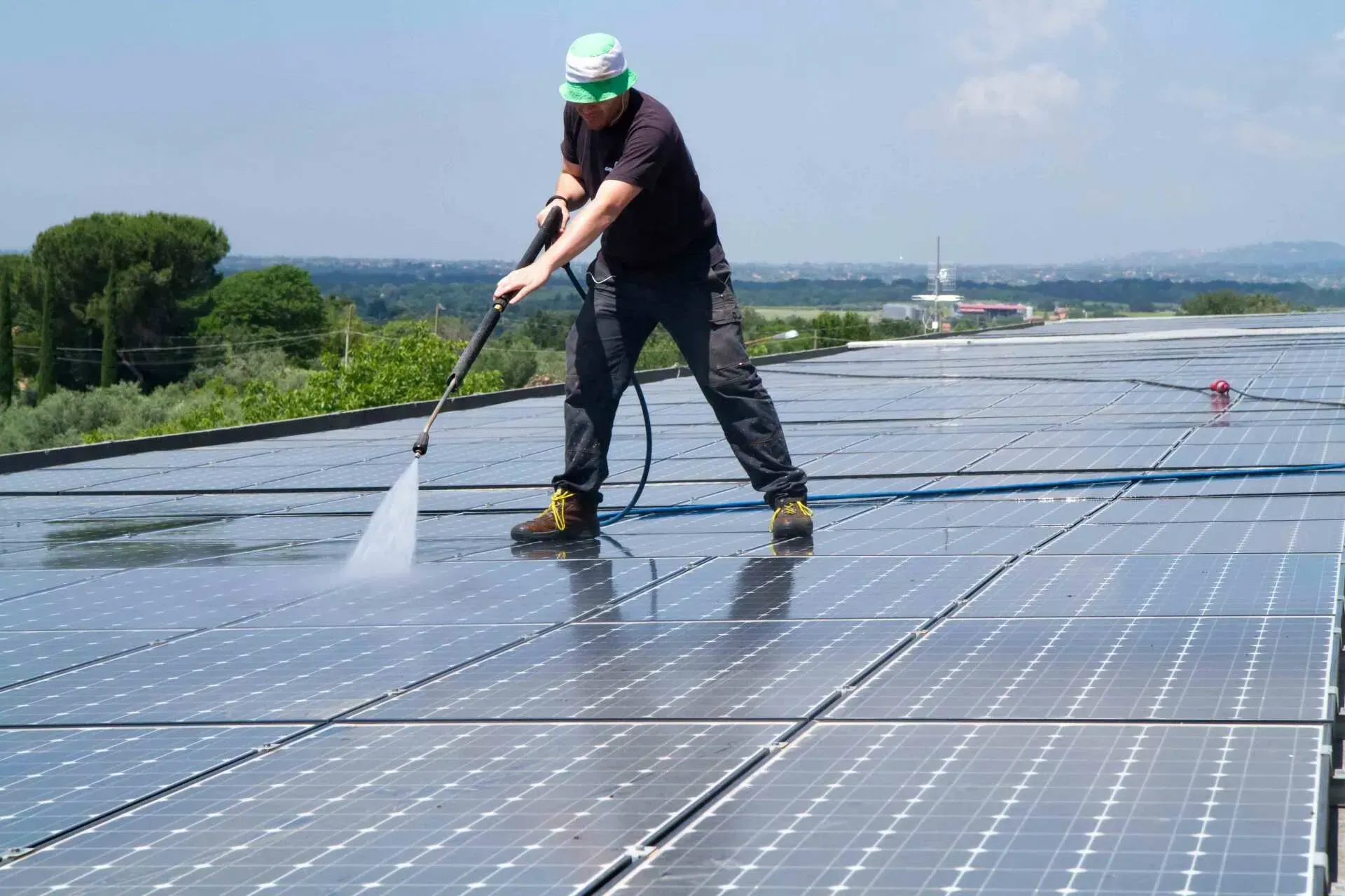 A Man Is Pressure Cleaning Solar Panel Alone — All Roof Restorations & Solar In Northern Rivers, NSW