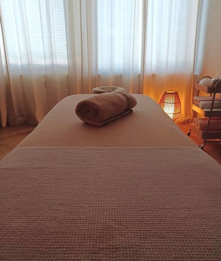 Een massagetafel met twee handdoeken erop in een kamer.