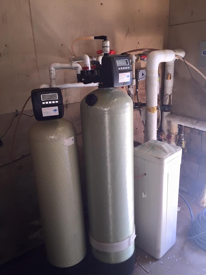 Two water filters are sitting next to each other in a room.