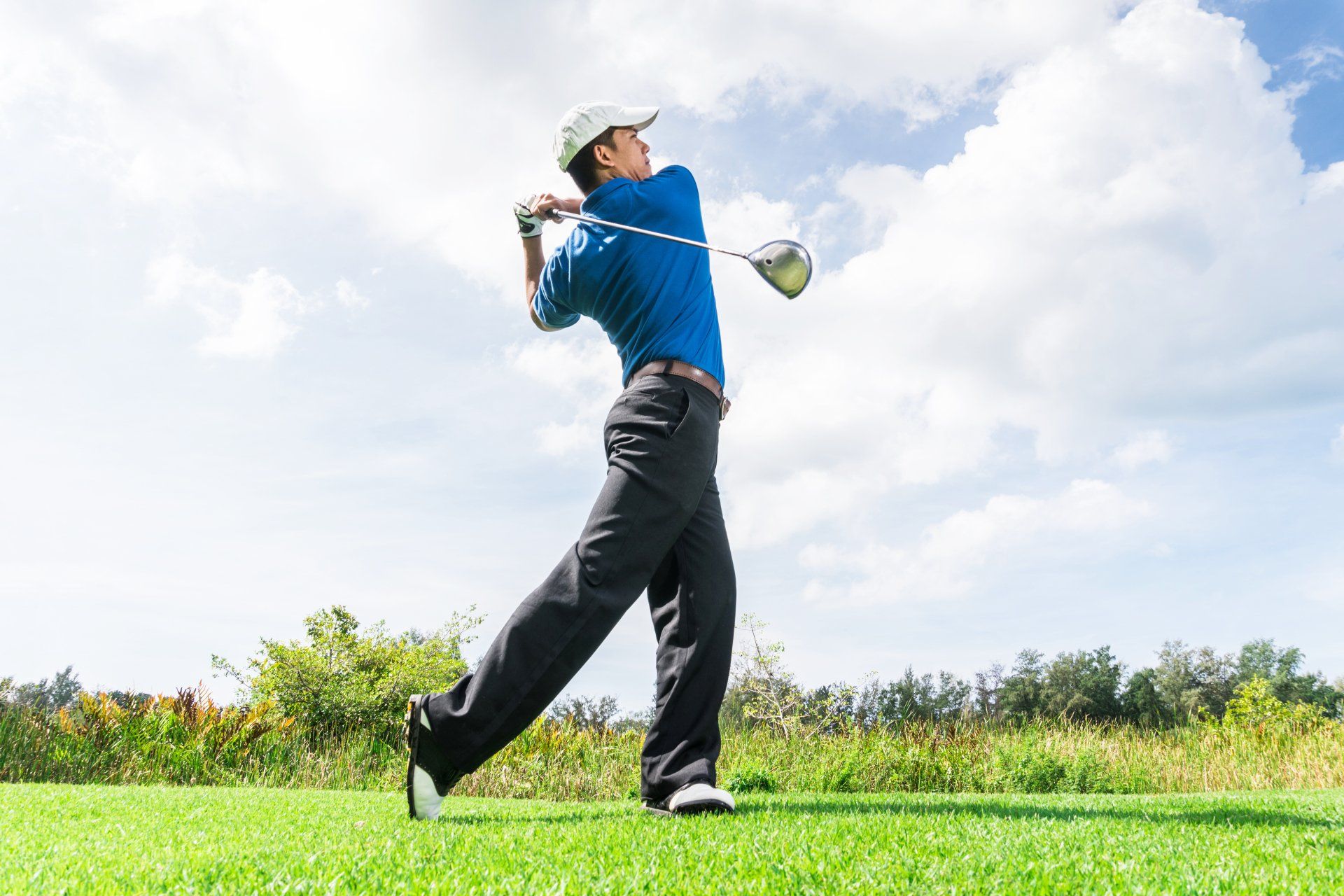 Asian golfer hit a golf ball by golf-club driver.