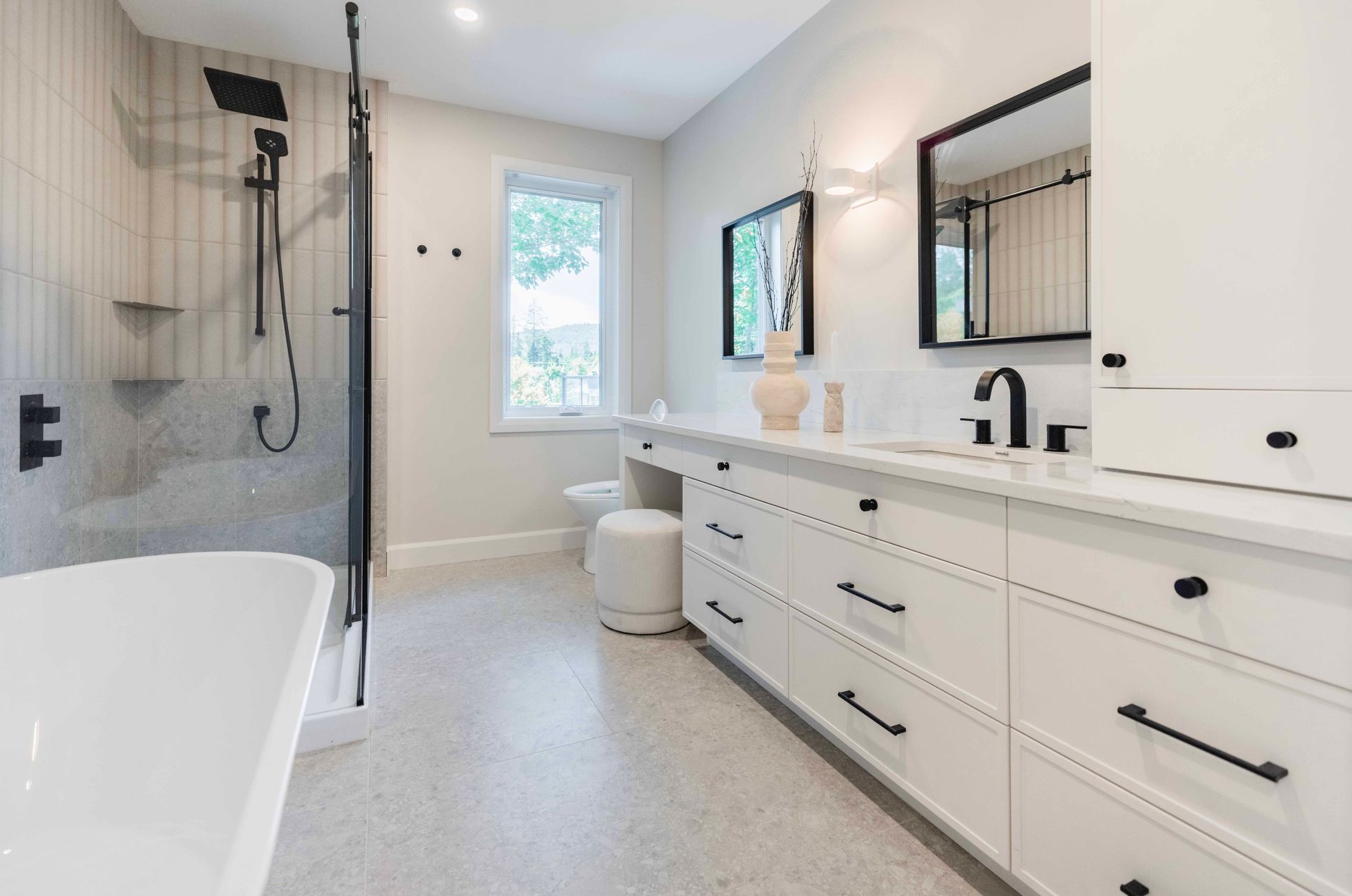 Salle de bains moderne blanche avec douche, meuble-lavabo et baignoire.