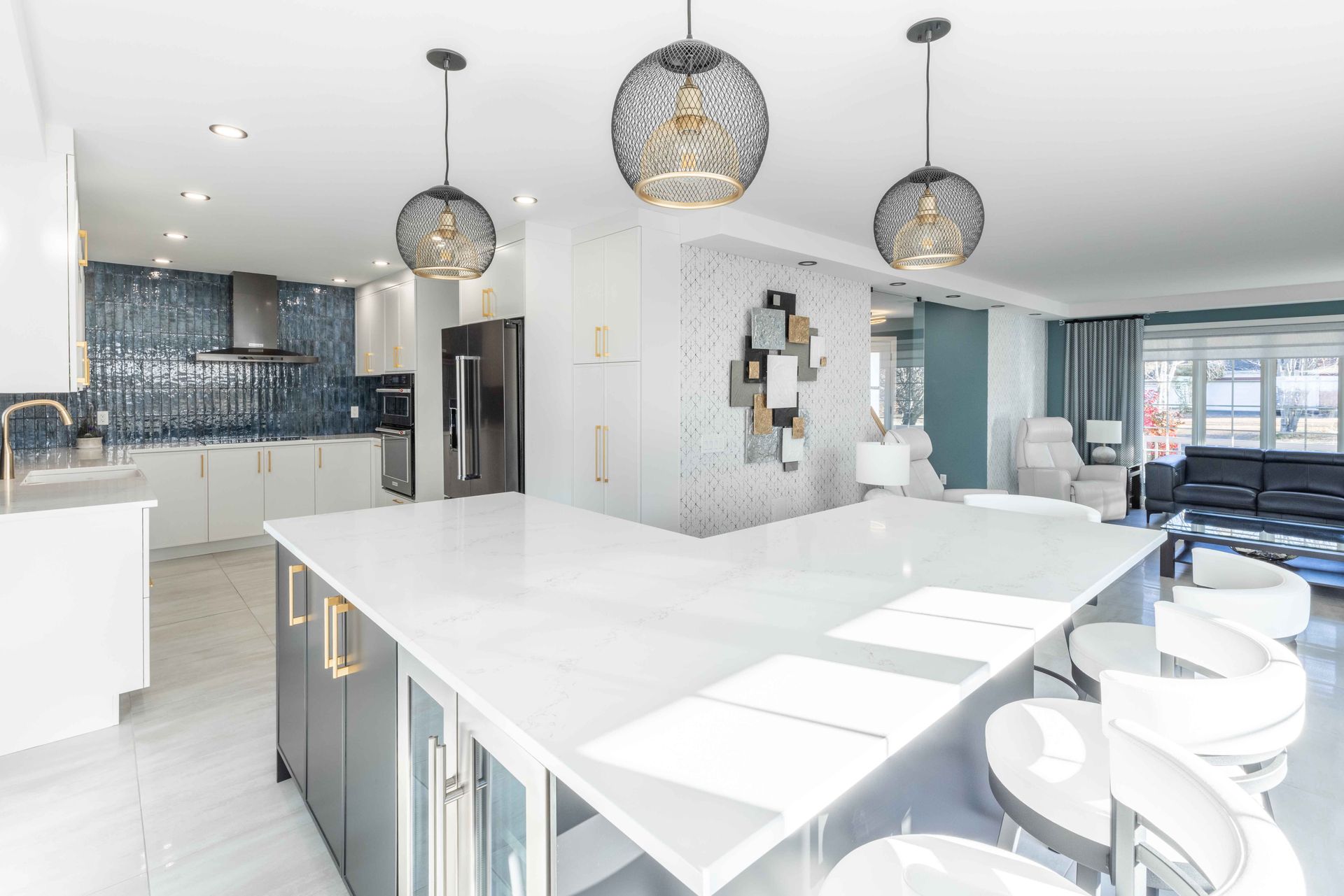 Cuisine moderne avec grand îlot blanc, suspensions lumineuses et crédence en carrelage bleu foncé.