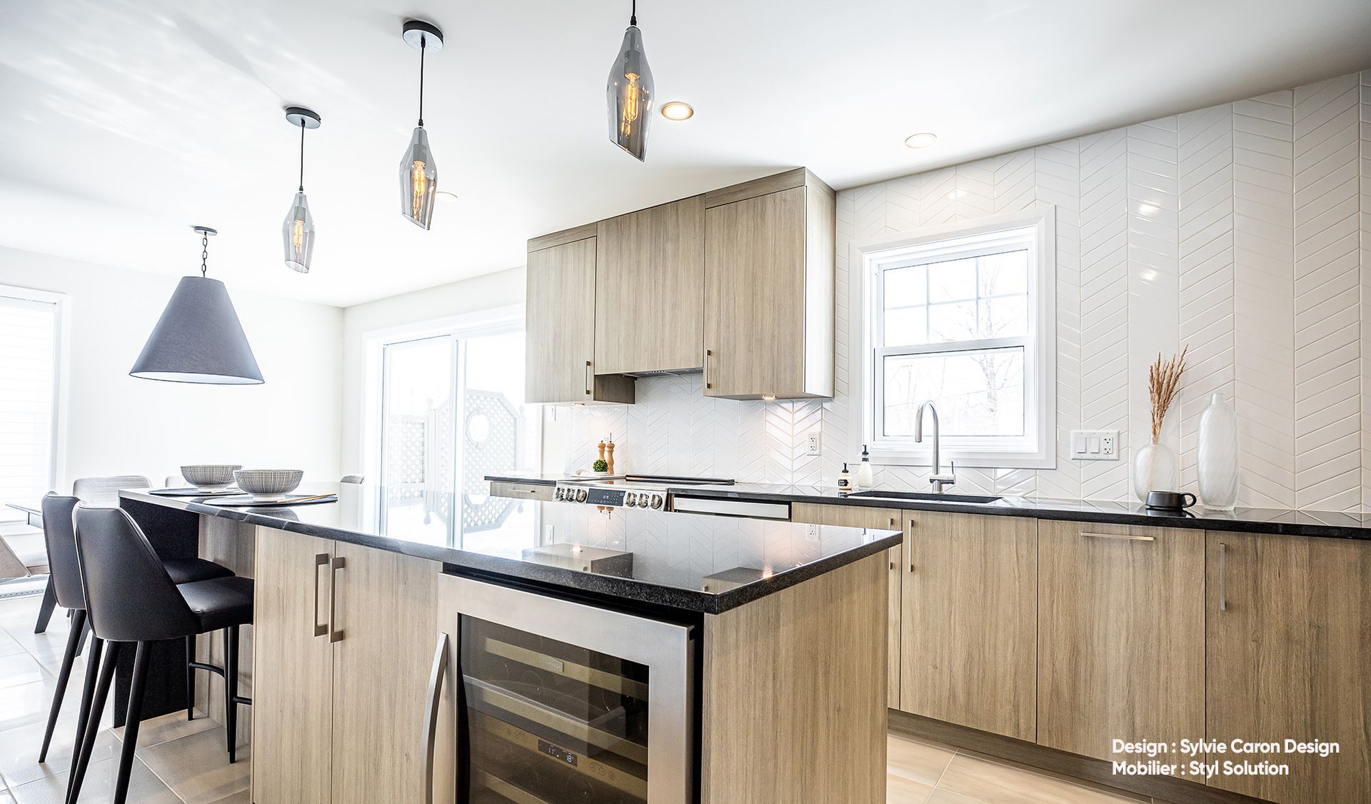 Cuisine moderne avec placards en bois, îlot central et suspensions lumineuses.