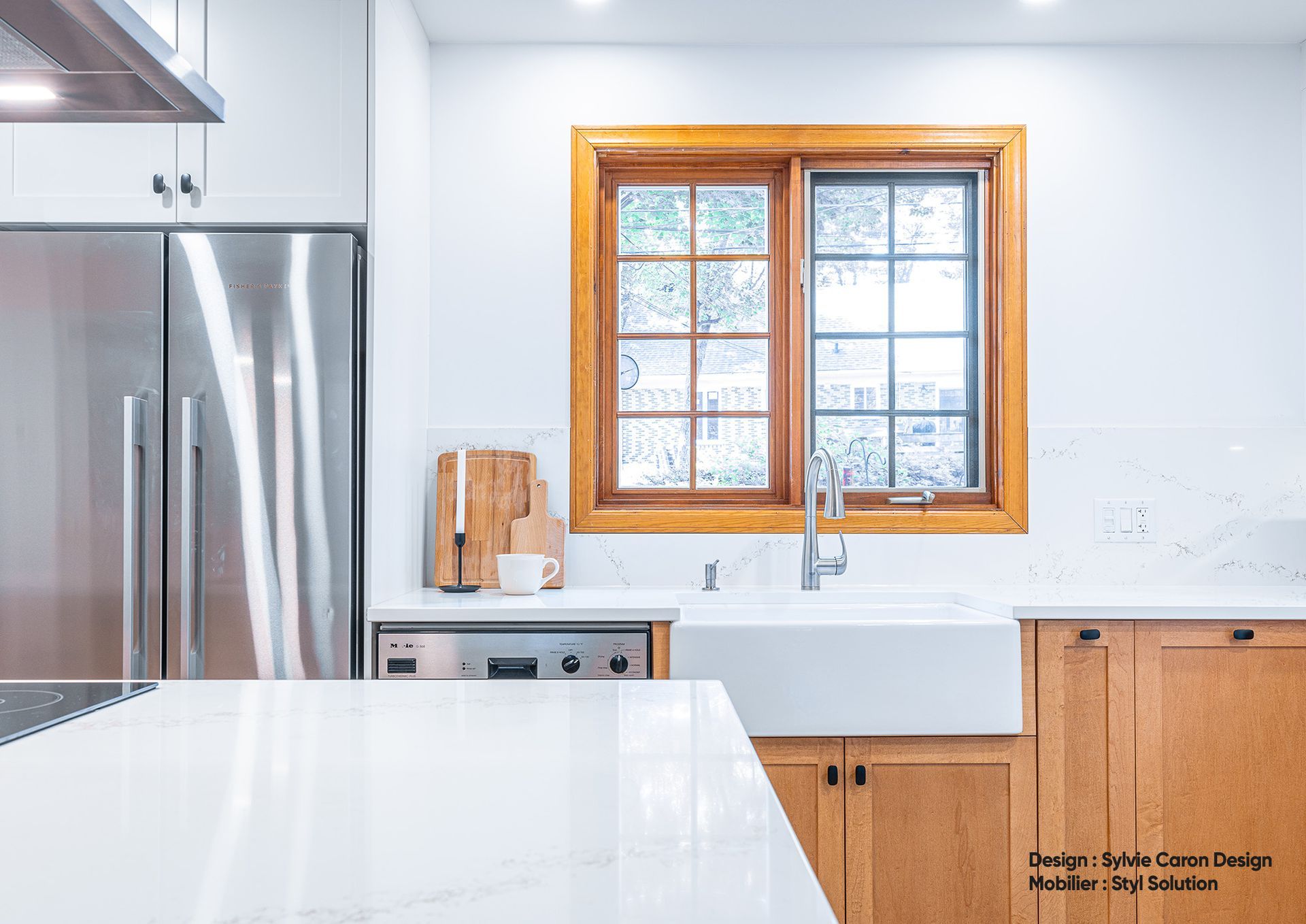 Cuisine moderne avec appareils électroménagers en acier inoxydable, armoires en bois, comptoirs et évier blancs