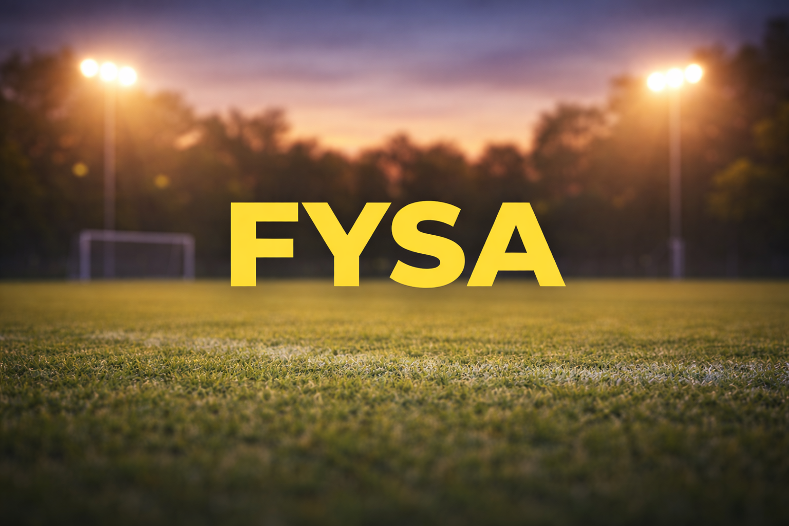 FYSA logo on a soccer field at dusk with lit stadium lights.