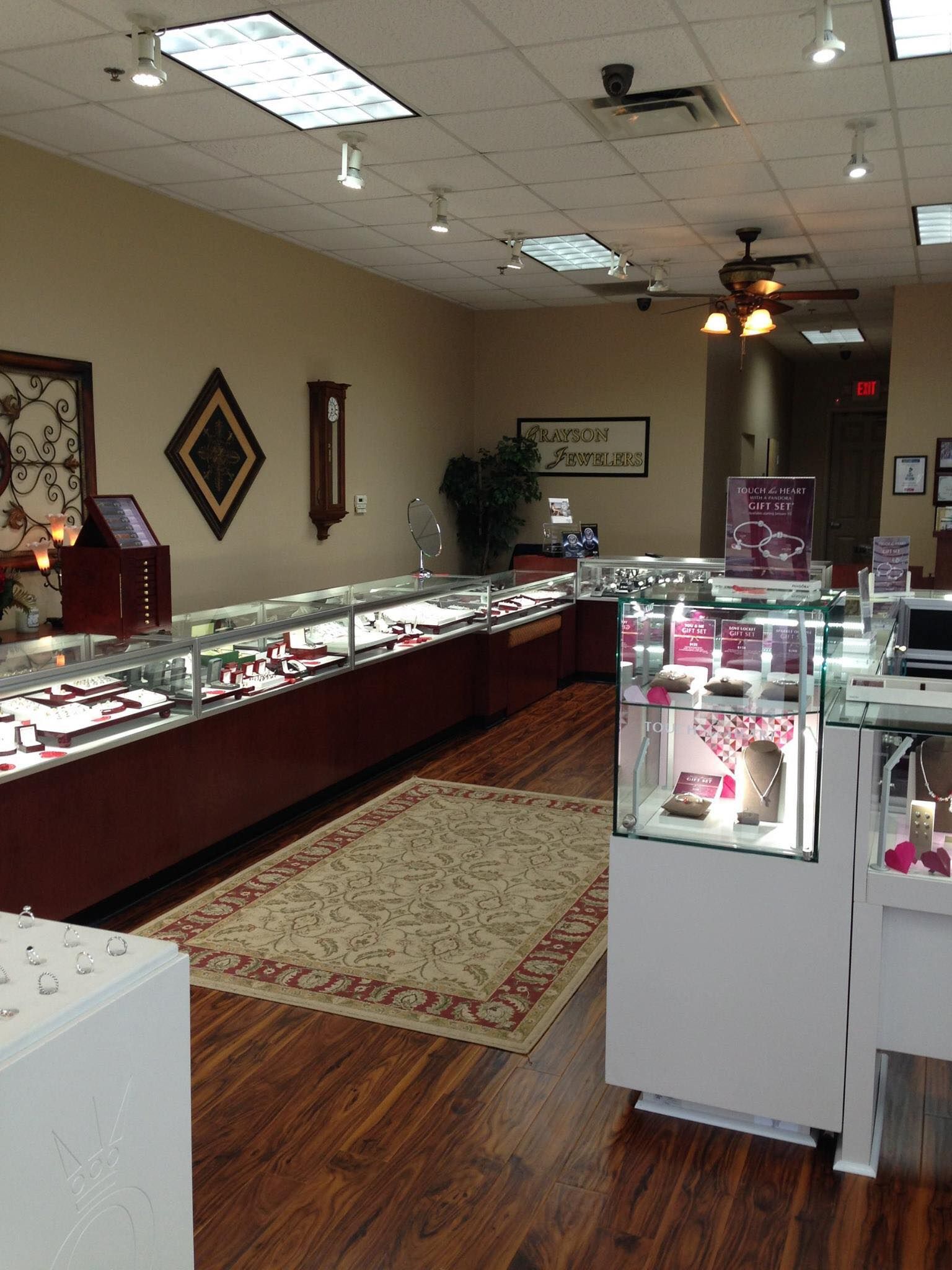 A jewelry store with lots of display cases and a rug on the floor