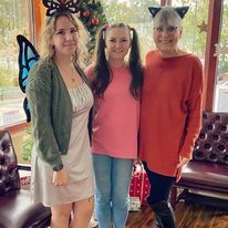 Three women are posing for a picture together in a room.