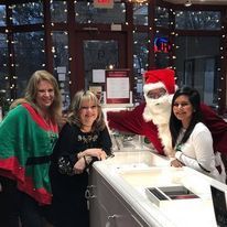 A group of women are posing for a picture with santa claus in a store.