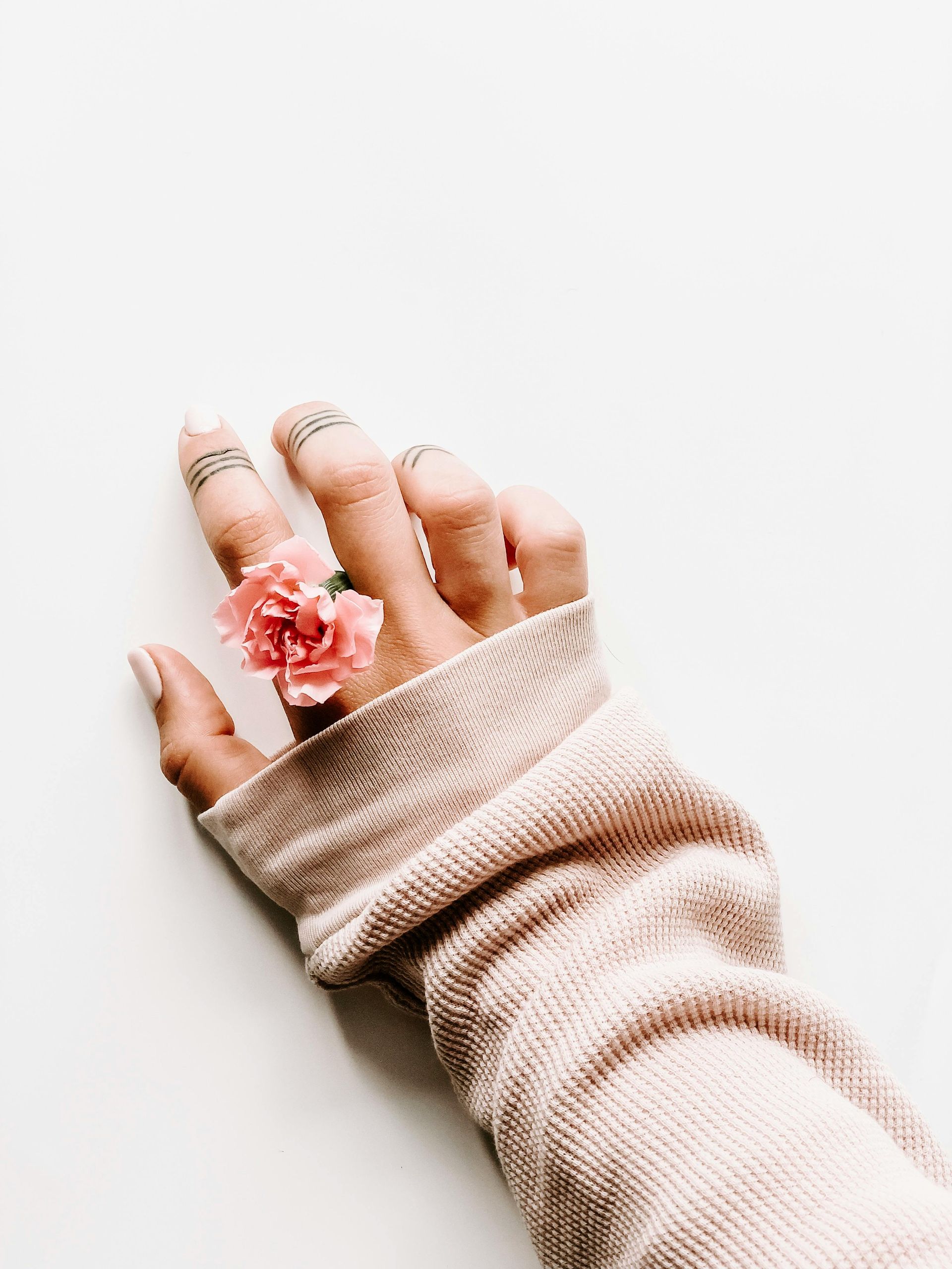 A woman is wearing a sweater and a ring on her finger.