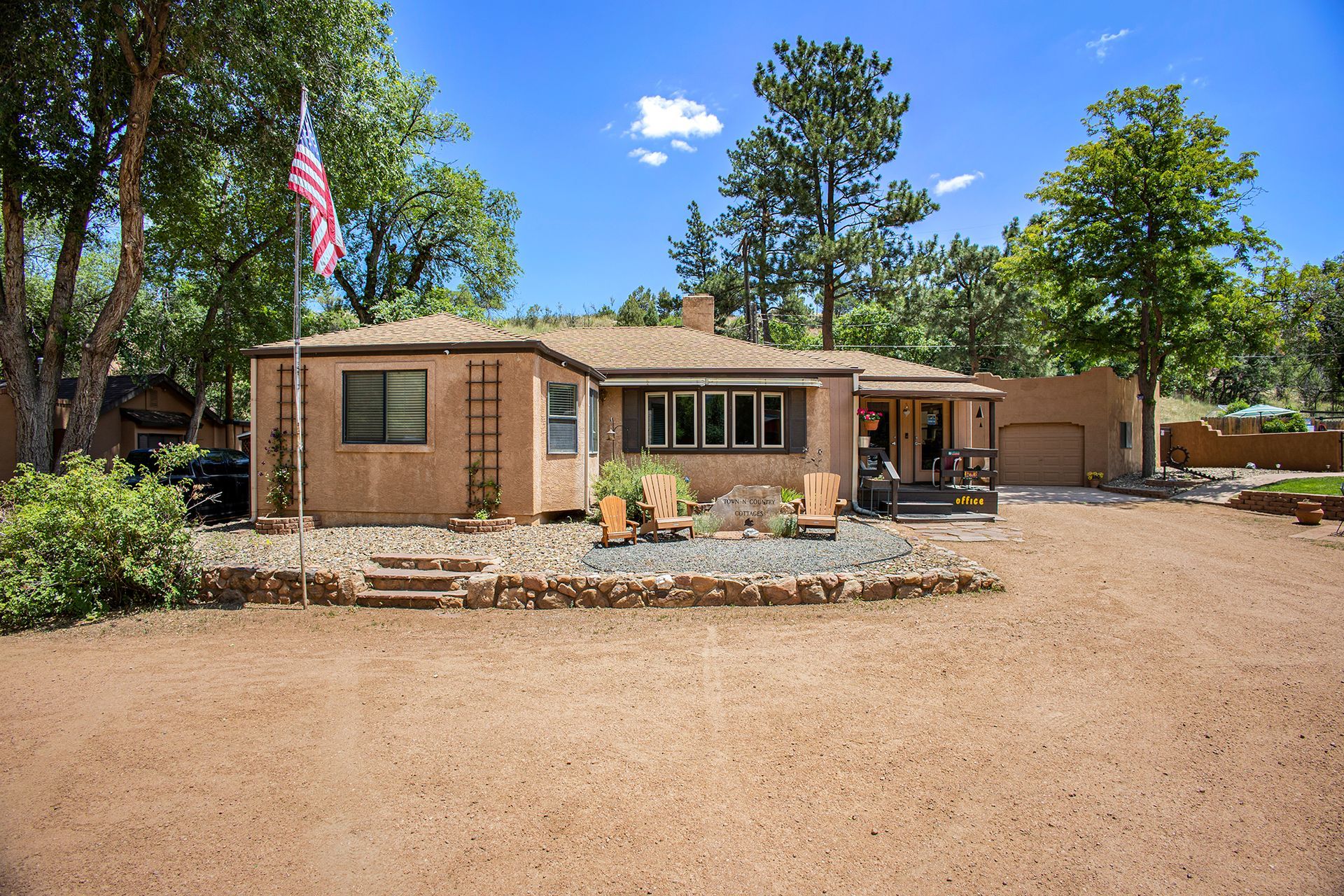 A house with a flag in front of it and trees in the background.