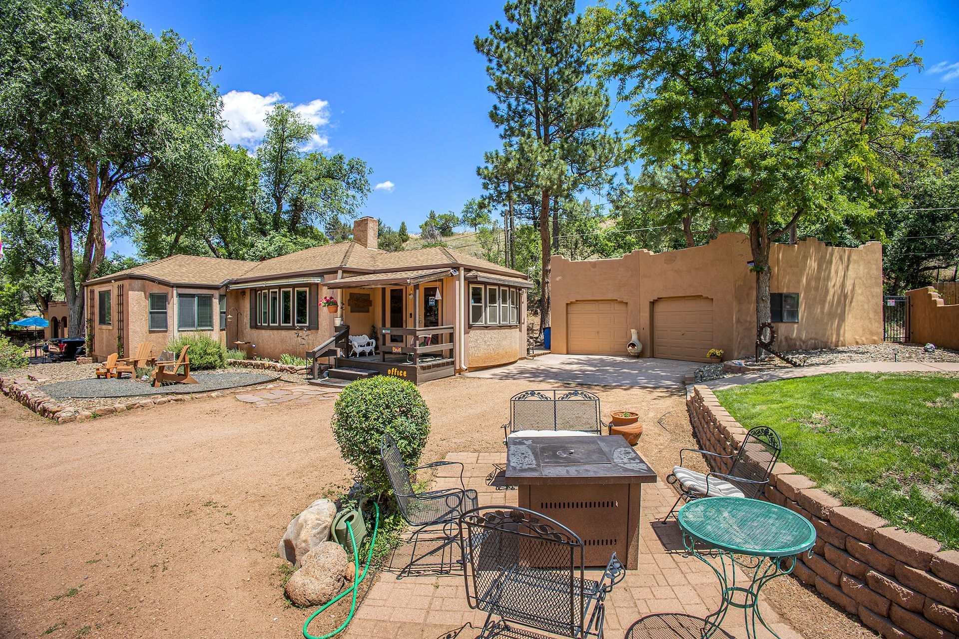 A large house with a patio area and a fire pit in front of it.
