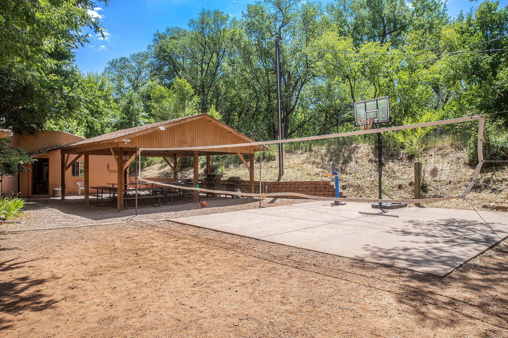 There is a volleyball net in the middle of a dirt field.