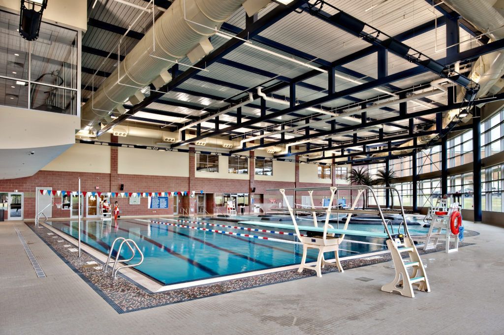A large indoor swimming pool with a diving board